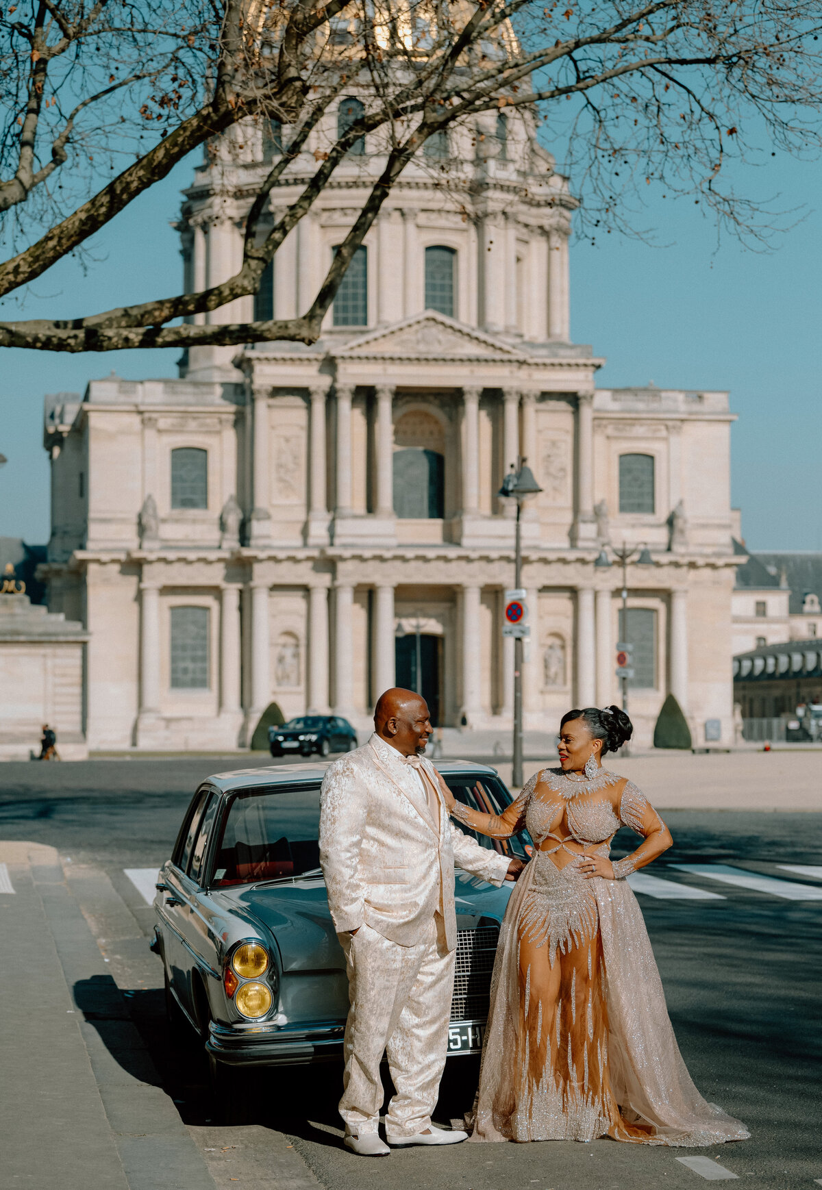 a bride and groom in Paris by a old building and a vintage car