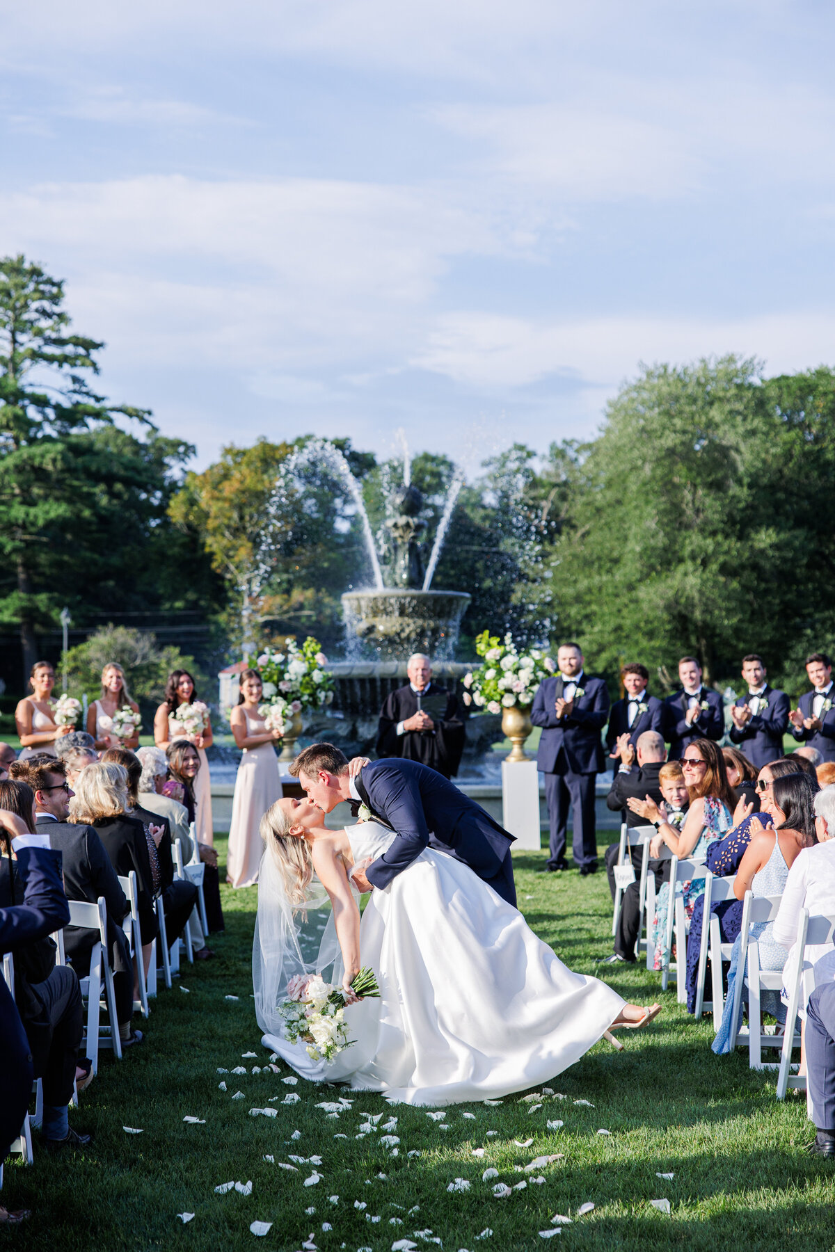 Groom dipping and kissing bride as they exit their Tupper Manor wedding ceremony