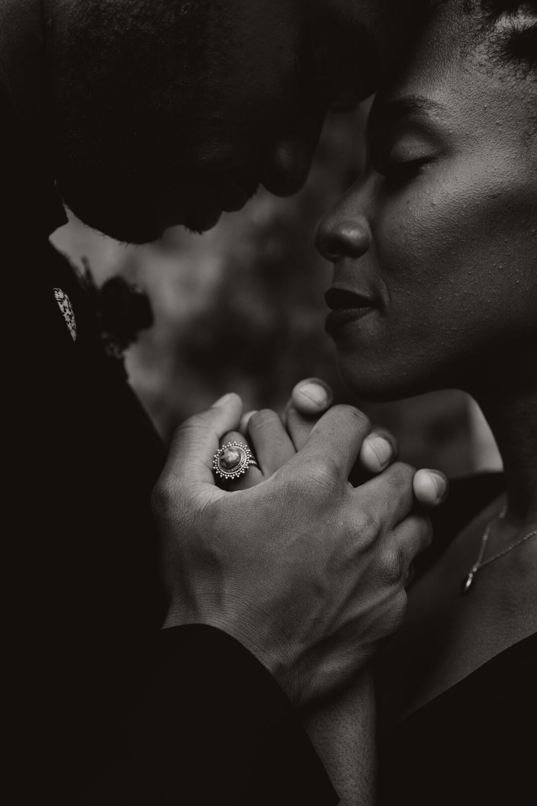 Black and white photo of couple embracing and holding hands