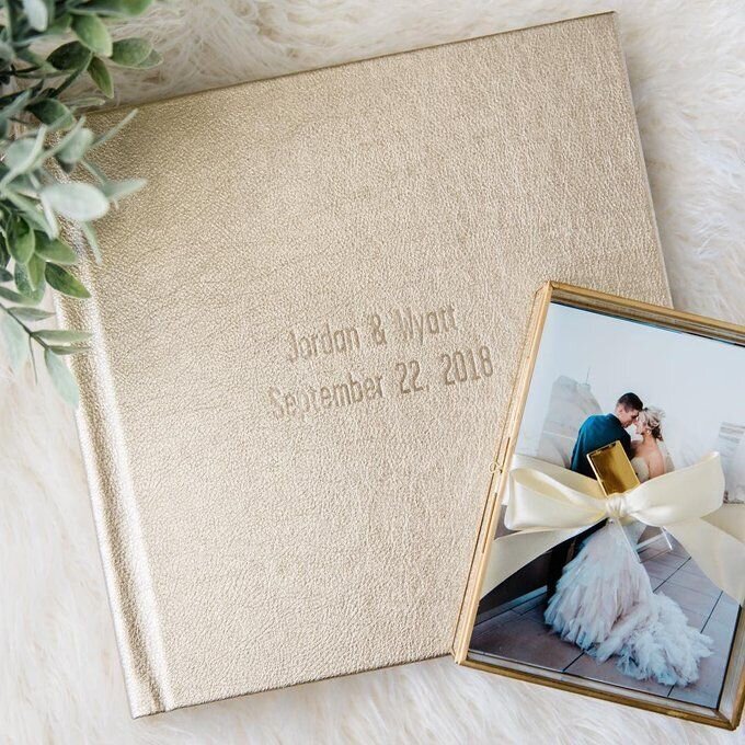 A gold leather wedding album that reads "Jordan and Wyatt" with flat lay photos of the bride and groom's wedding day.