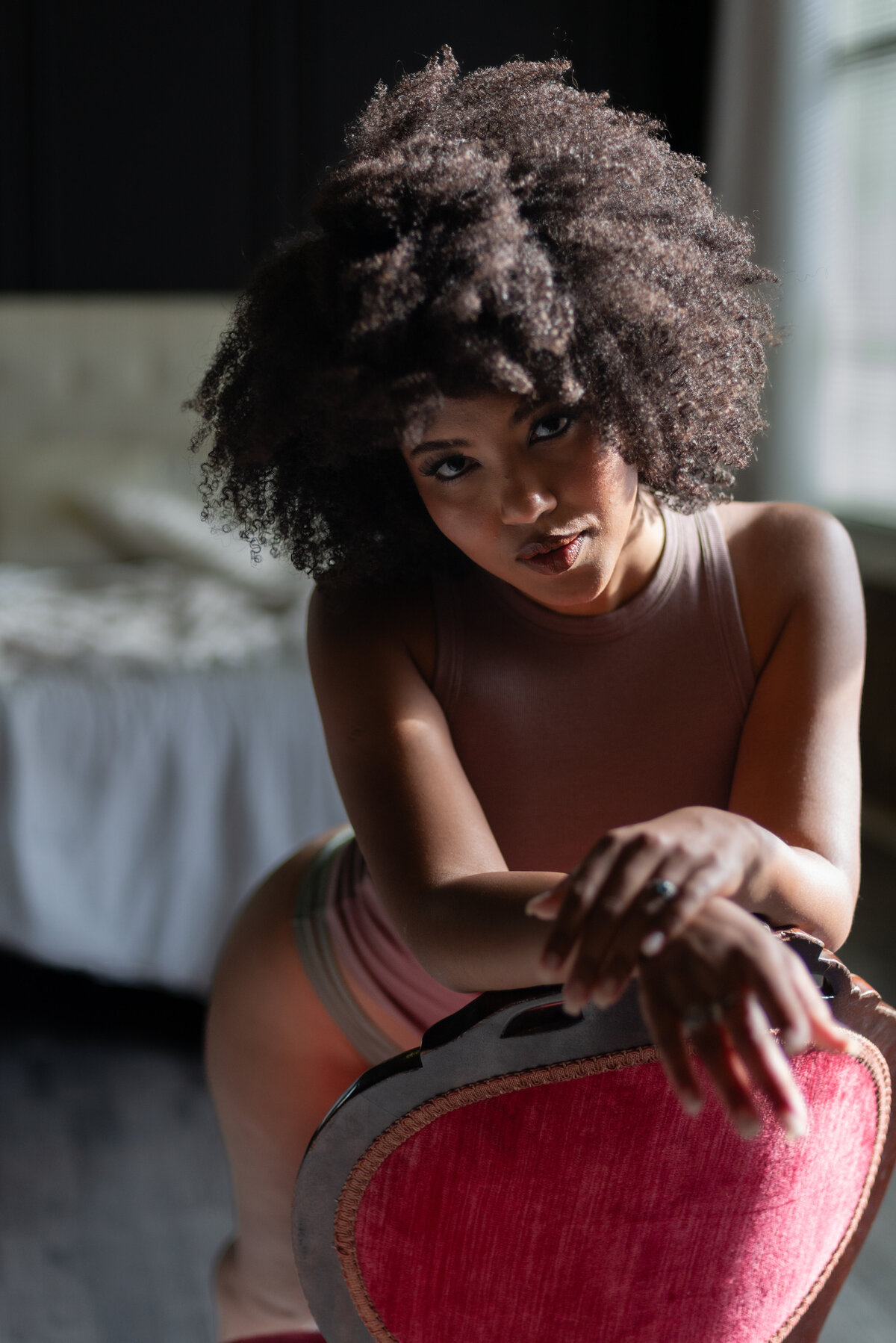 Romantic boudoir image with soft shadows highlighting a woman’s serene expression.