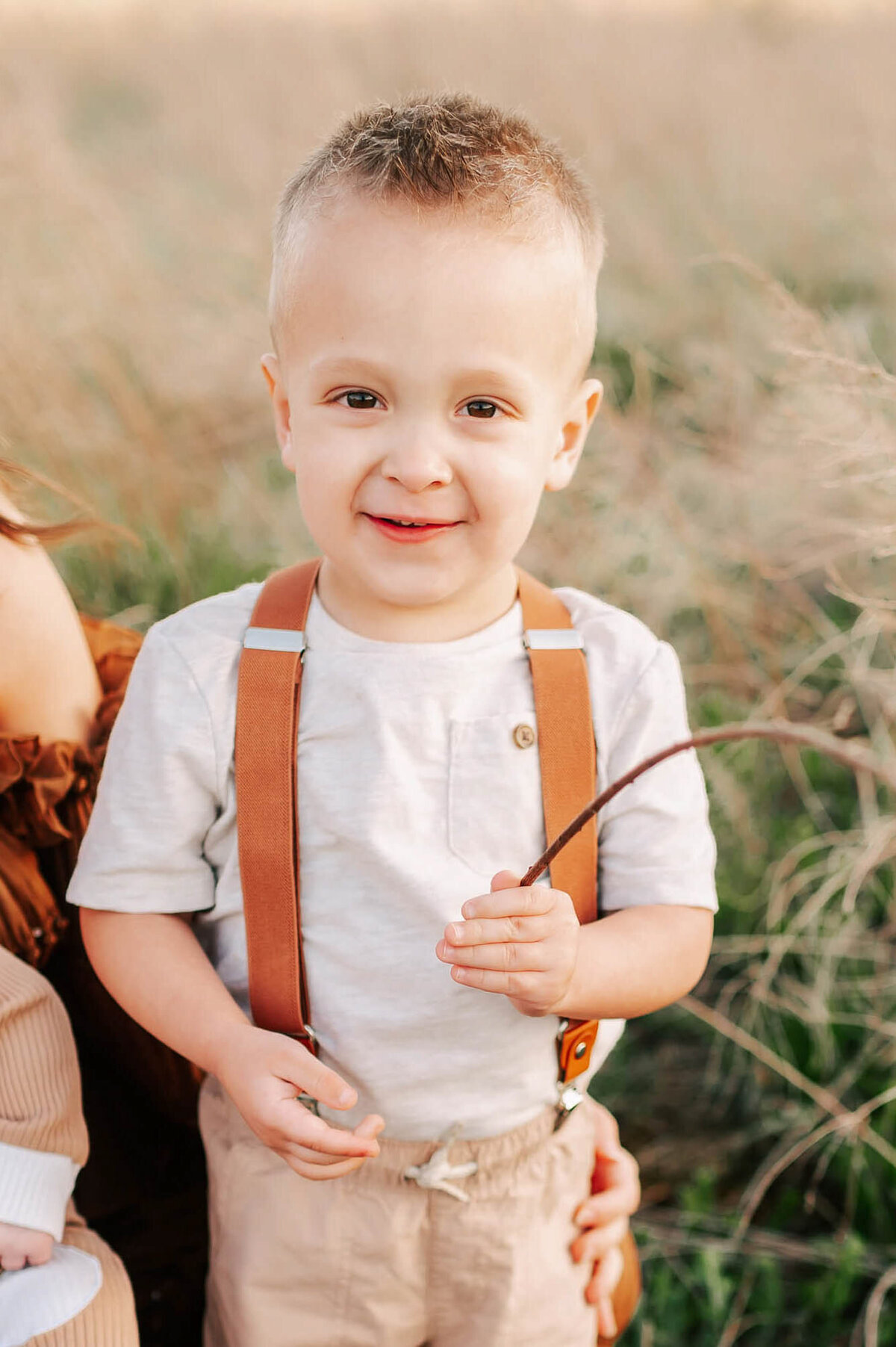 family portrait  in Branson of boy holding a stick outdoors
