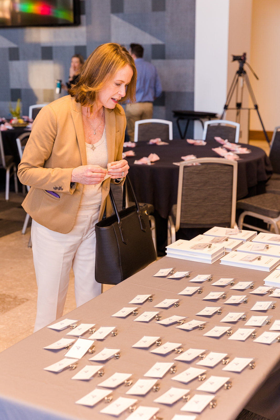 Business woman looking for her event tag during a networking breakfast event in Atlanta by event photographer Laure Photography