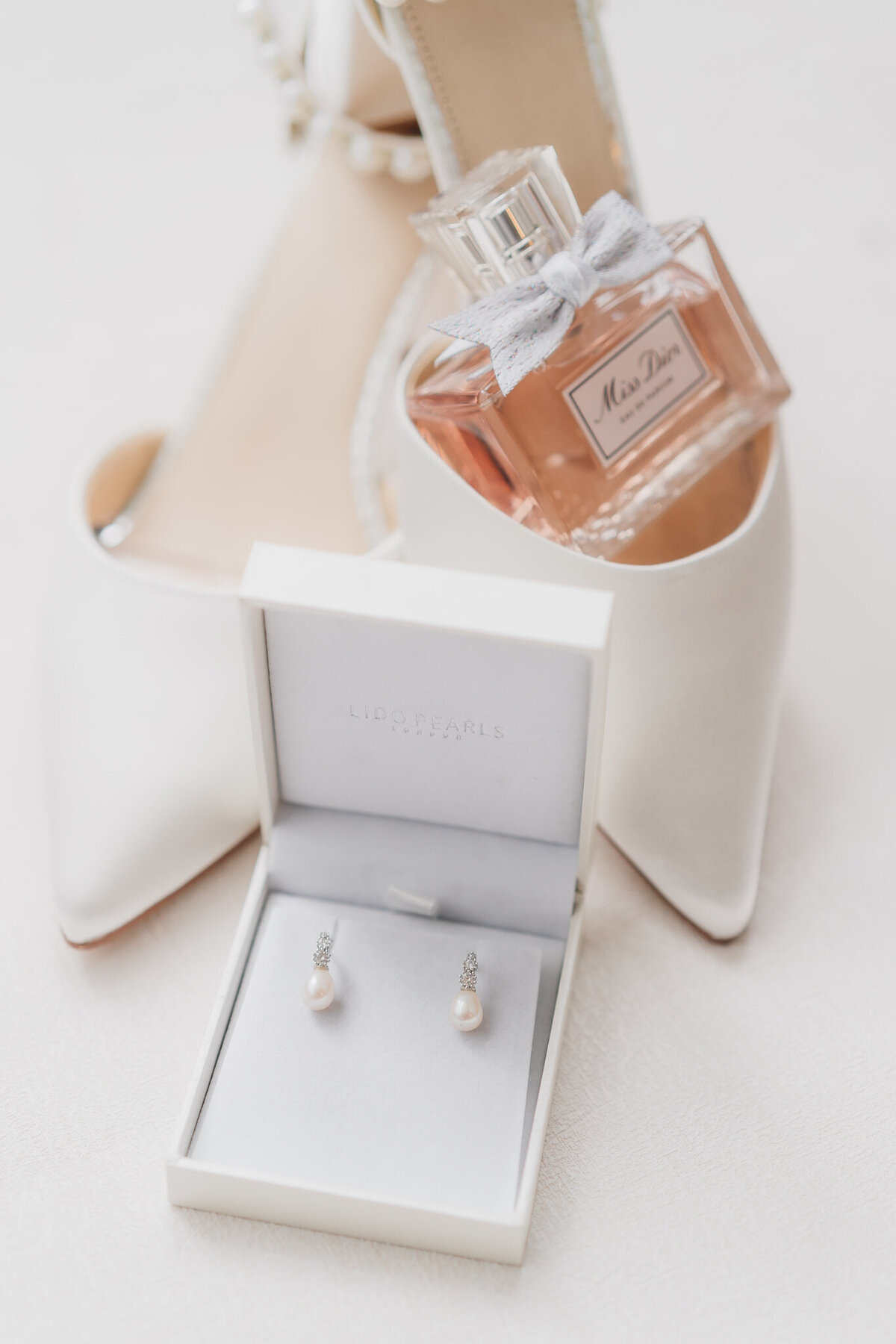 wedding earrings shoes and perfume taken by a light and airy Cheshire wedding photographer