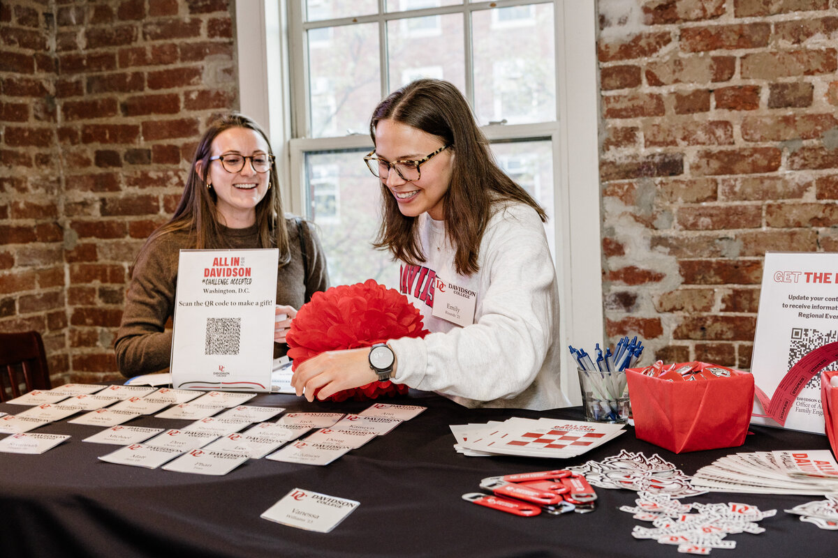 Candid moment of a staff member preparing the registration desk for an event at a University captured by Certified Professional Photographer BrandGo Photos Event Photographer