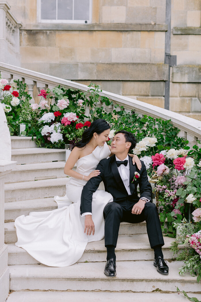 bride and groom portrait sitting on the stairs at botleys mansion