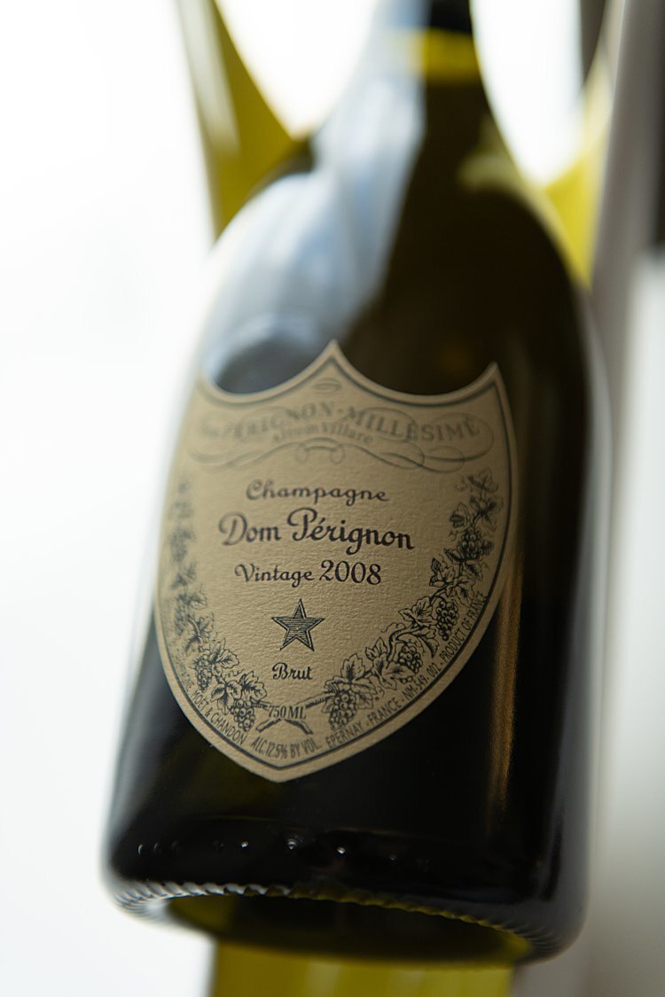 Bottle of Dom Perignon resting on yellow and white vase