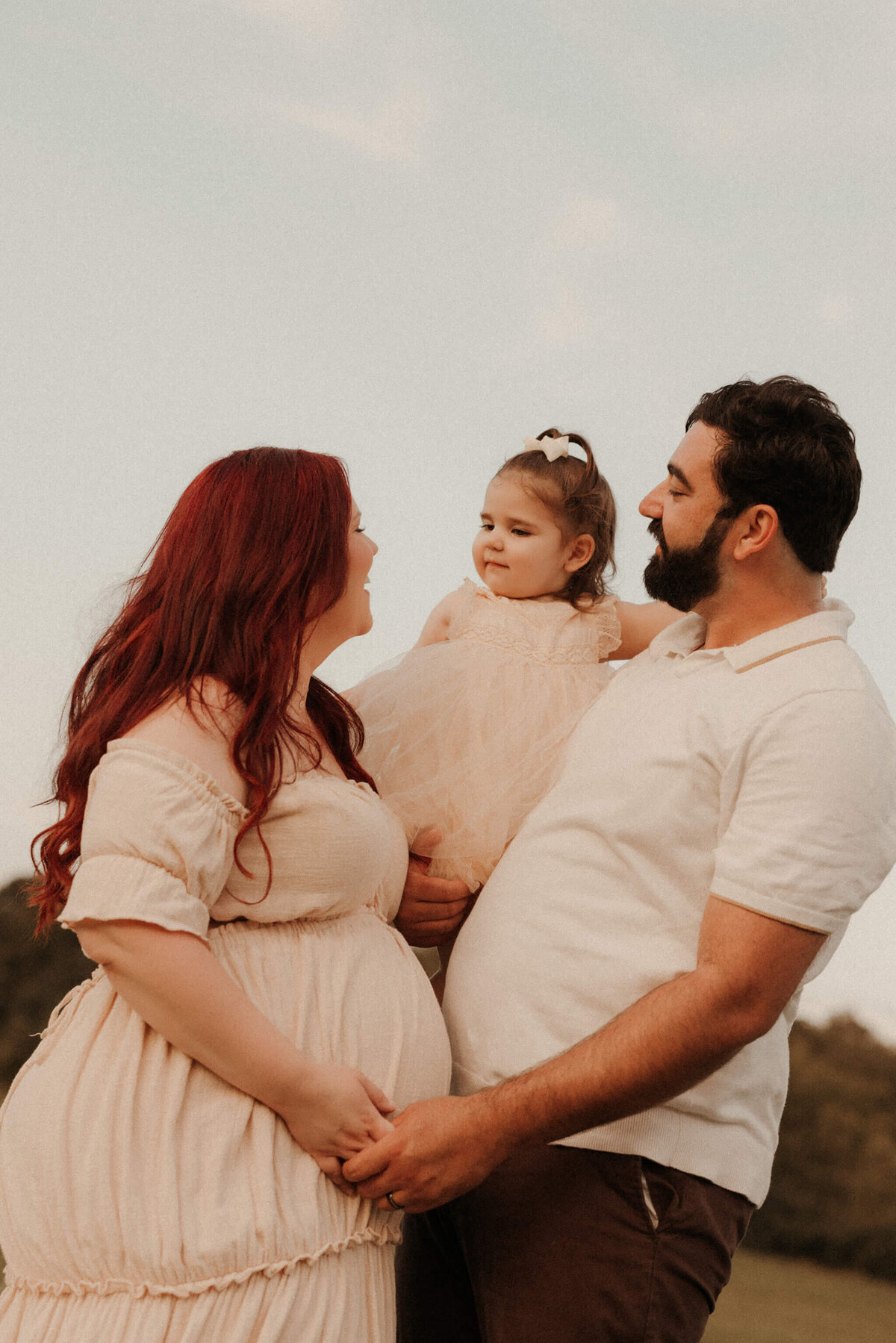 Pregnant woman standing in tall grass during Murfreesboro TN outdoor maternity photography
