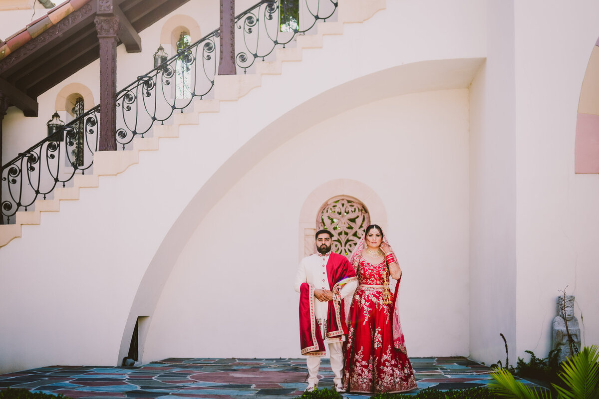 indian bride and groom standing at the vanderbilt museum and observatory in long island ny on the wedding day