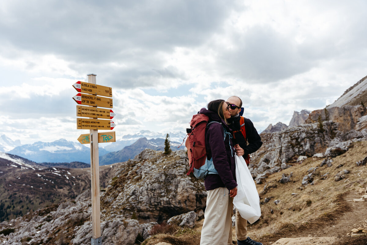 Couple standing by trail signposts during alpine hike