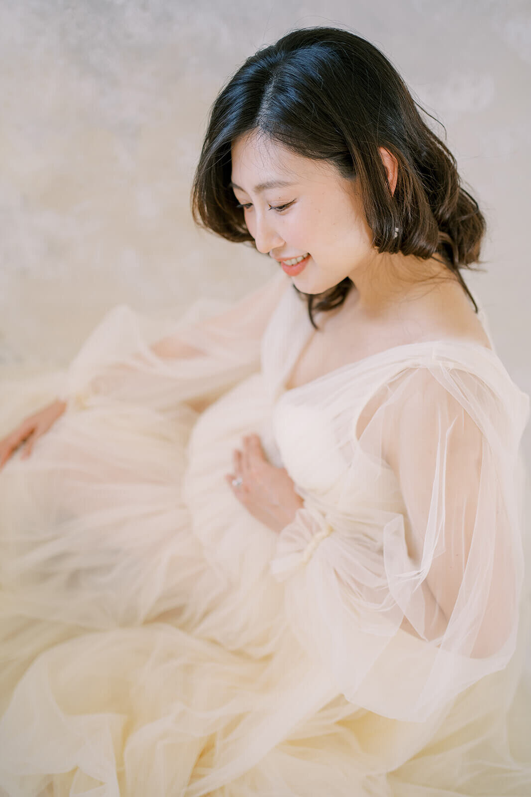 Experience the elegance of maternity as pregnant mum dons a mesmerising cream tulle maternity gown in a Gold Coast studio