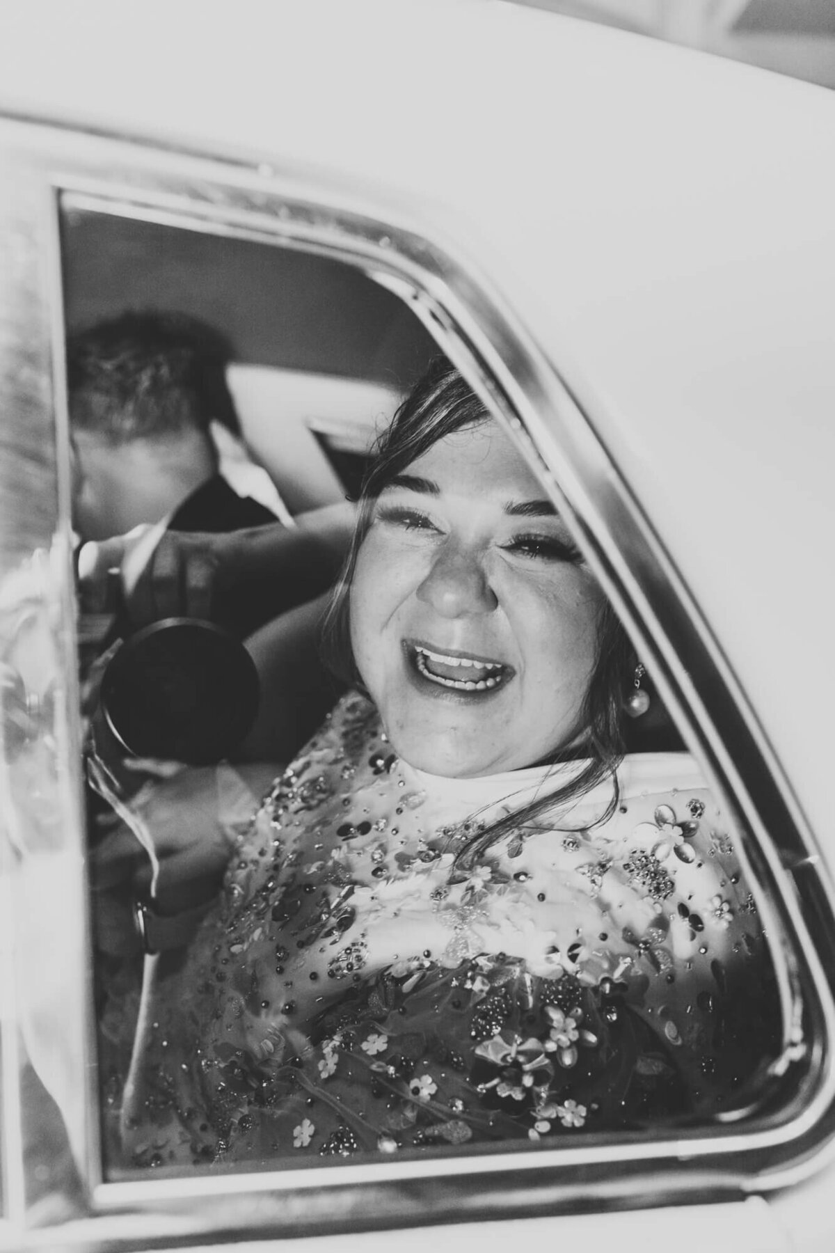 bride smiles so happily as she leaves the reception with her husband.