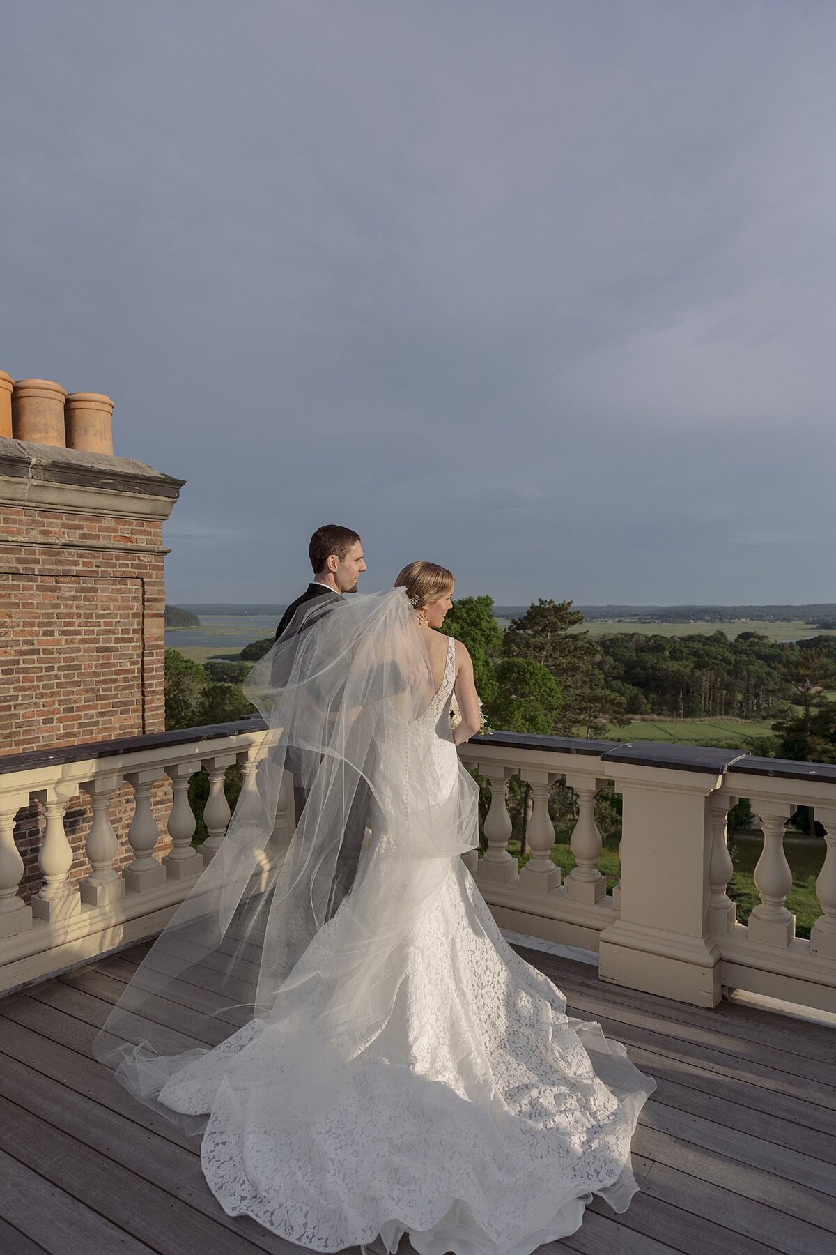 Bride and Groom stand on rooftop of Crane Estate. Deborah Zoe.