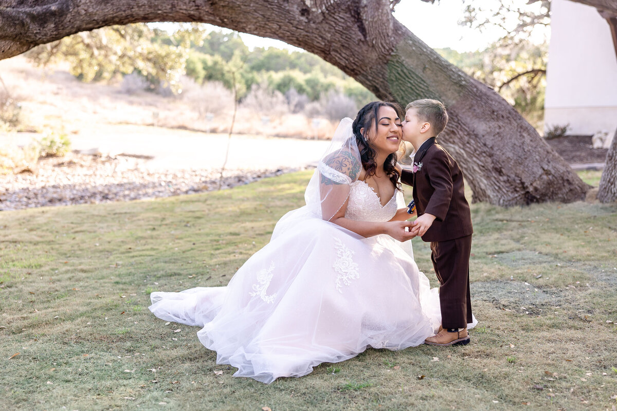 ring bearer kisses bride on cheek at Texas Hill Country wedding