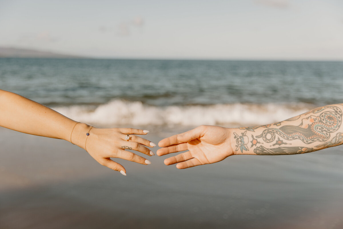 Hawaii Engagement Photographer captures man and woman holding hands at ocean