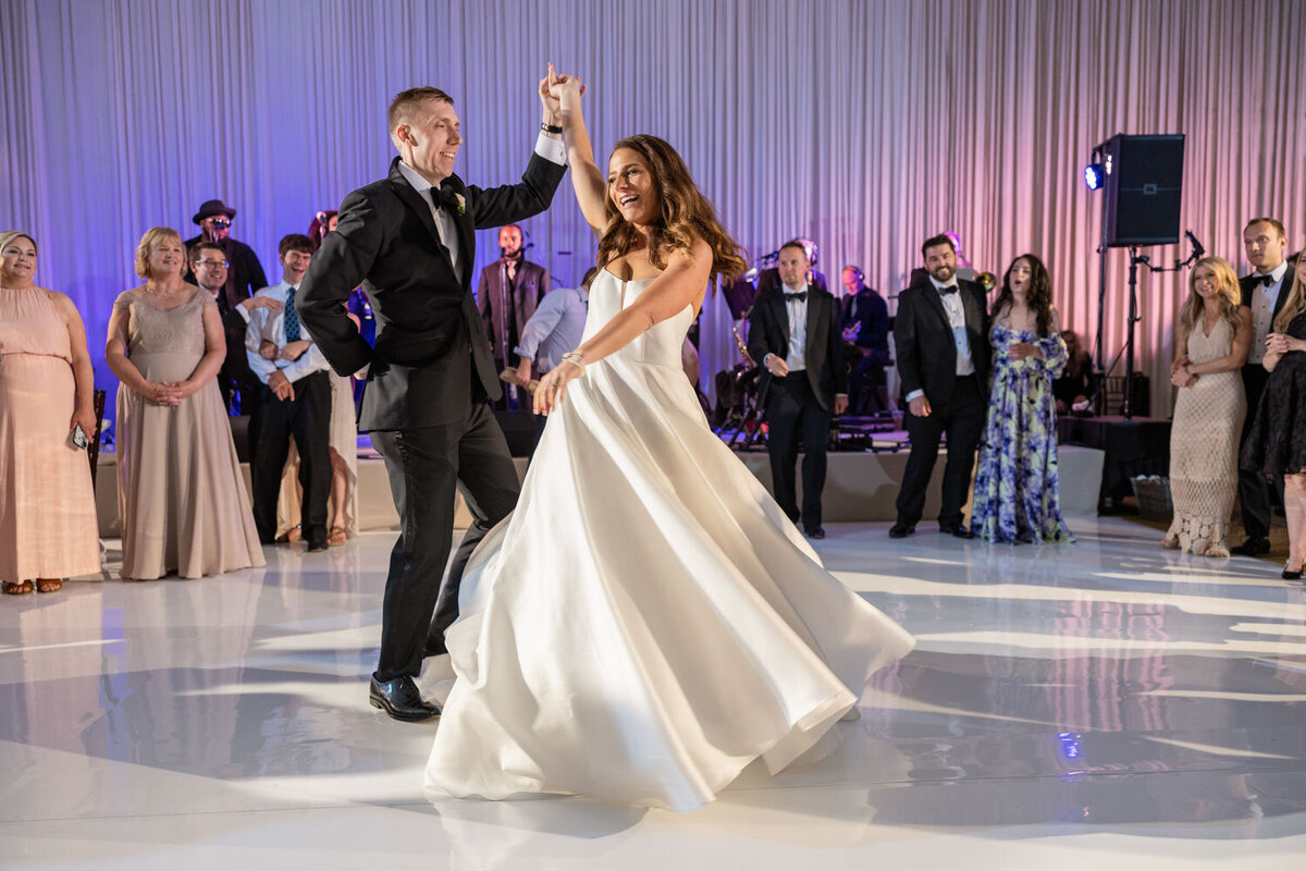 A bride and groom are dancing at their wedding reception