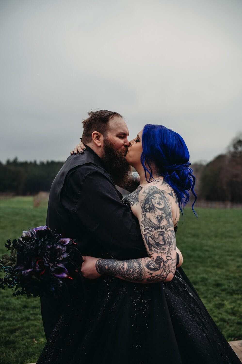 Gothic couple kiss with a moody backdrop