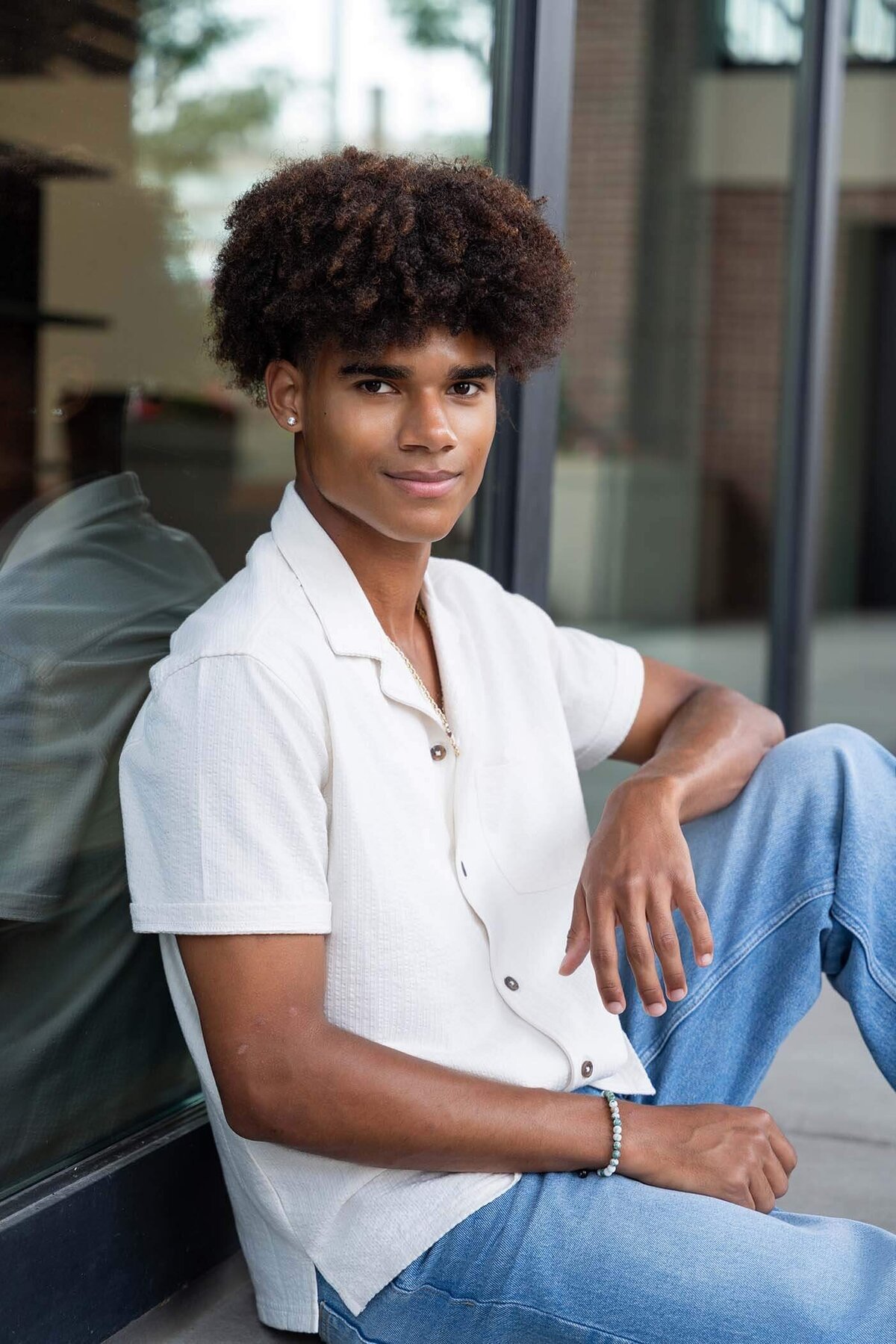 senior-boy-sitting-in-city-casually