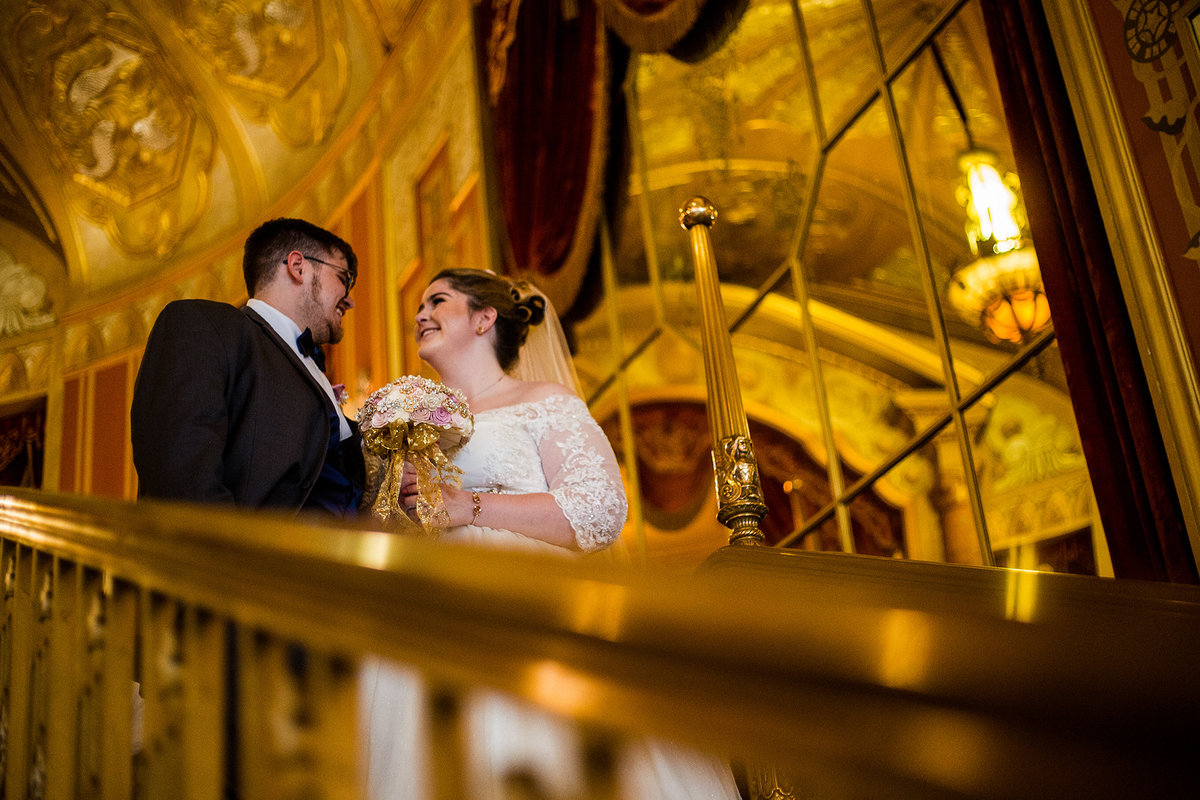 Bride and groom pose on the Grand Staircaseat the Warner Theatre