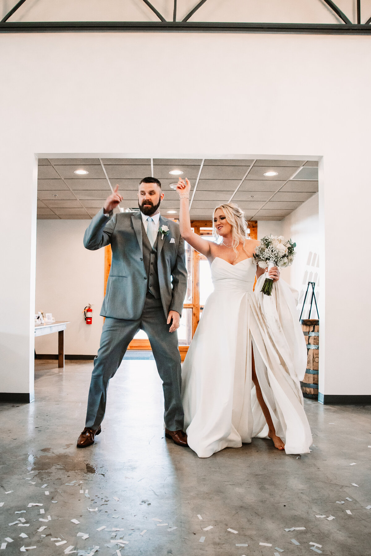 Newlyweds dance with fingers in the air while entering their reception at Aspen Sky Winery and Distillery