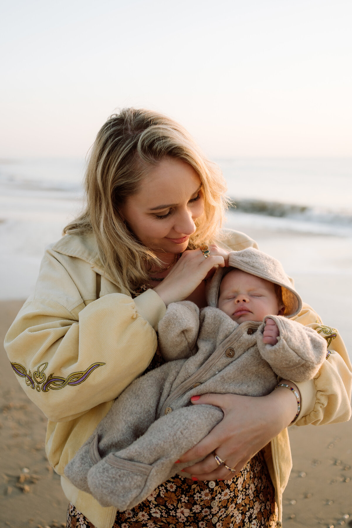 Newborn fotografie van een baby van enkele weken oud, vastgelegd in huis en aan zee. Intieme momenten van een pasgeboren baby, vol met de heerlijke chaos van het gezinsleven.