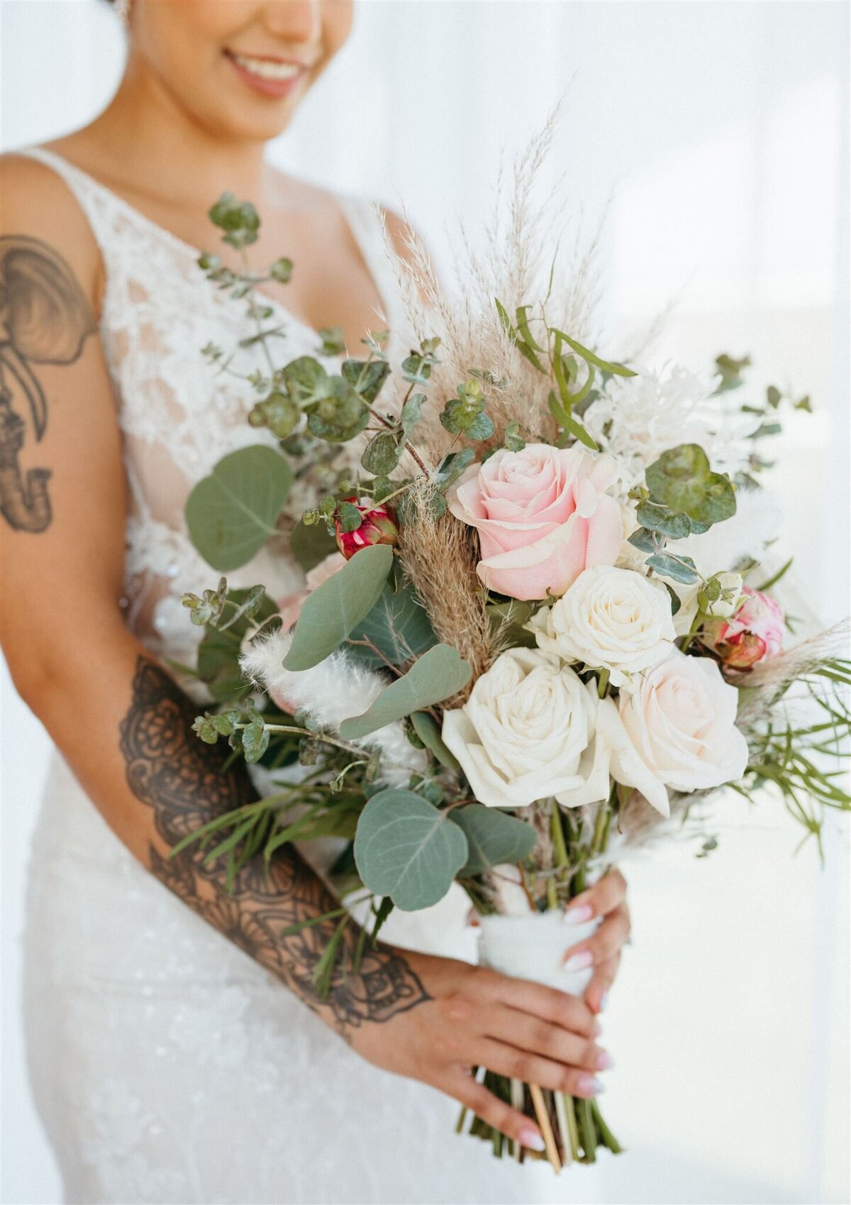 a bride holding a bouquet of pink flowers