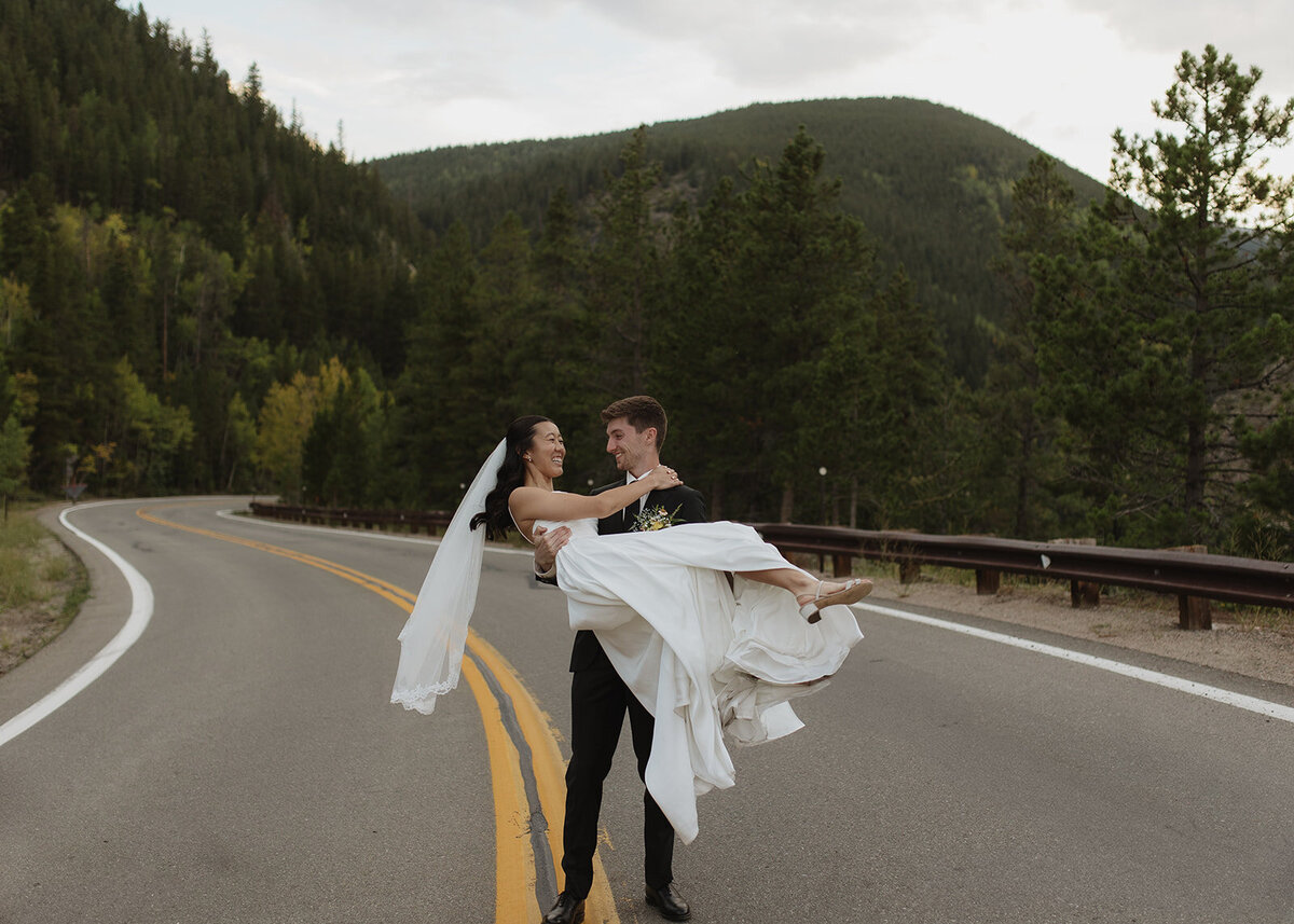 Bride and groom spinning around in the middle of the road