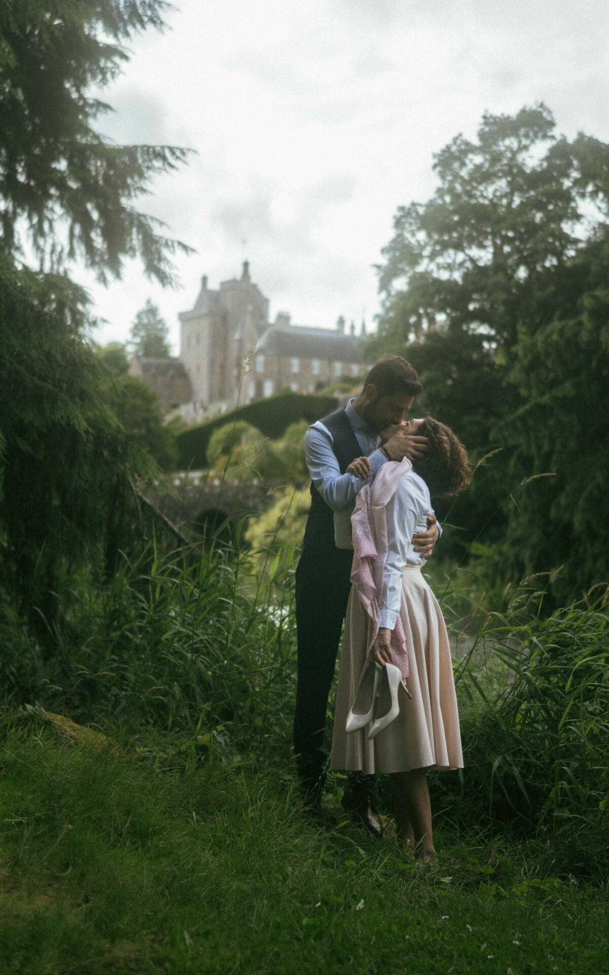 Capture the magic of a couple sharing a tender kiss in a serene moment of connection. This intimate photoshoot highlights their love, framed by the natural beauty surrounding them