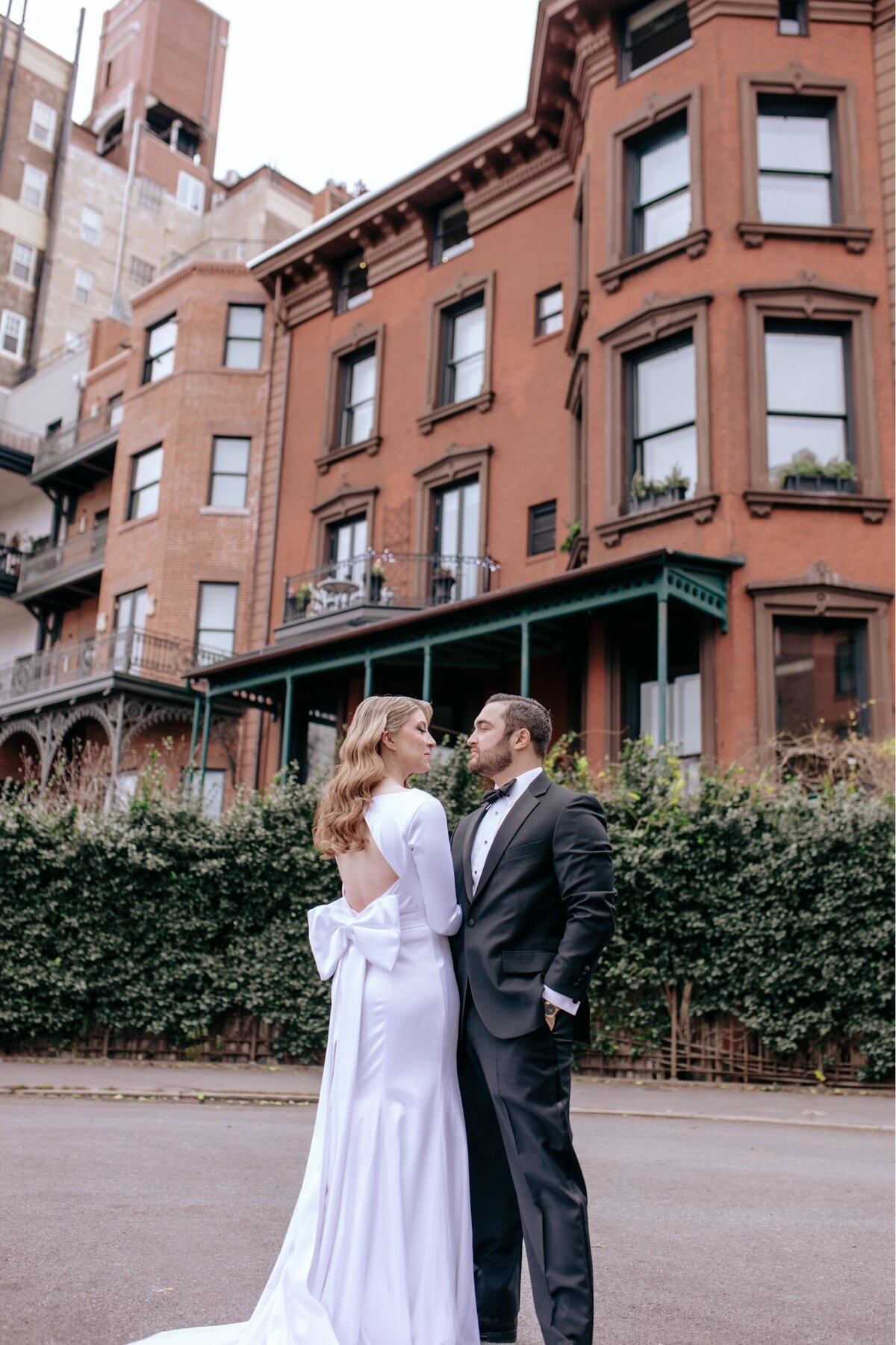 Bride and groom gazing at one another in in fron of a townhouse in NYC.