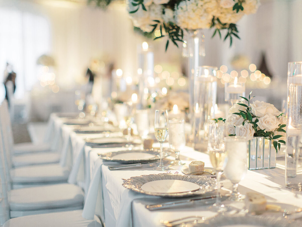 An all white floral decor tented wedding reception details