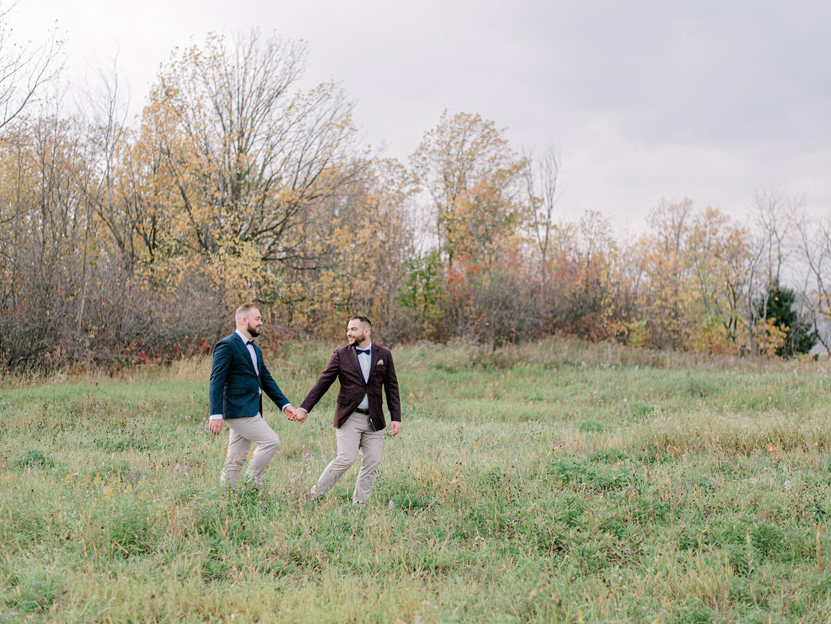 Beautiful same sex couple walking through field holding hands, lgtbq+ wedding inspiration, captured by Julie Jagt Photography, fine art wedding photographer in Vancouver, BC. Featured on the Bronte Bride Vendor Guide.