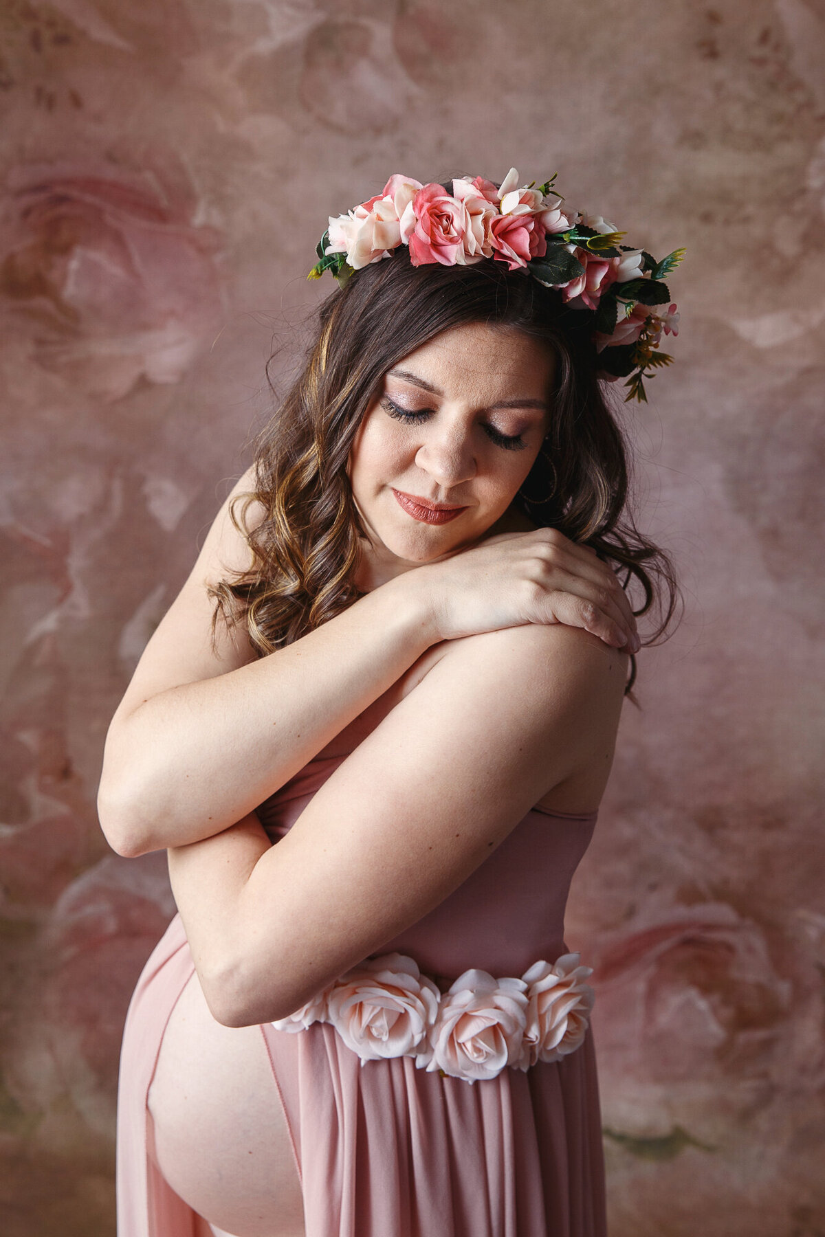 Closeup Maternity Portrait of a woman dressed in pink with her baby bump showing