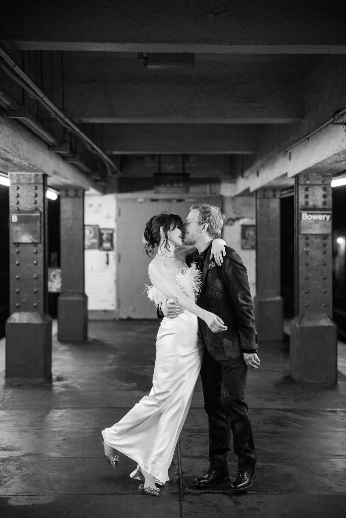 A bride and groom pose on a New York City subway platform for their wedding day Photos