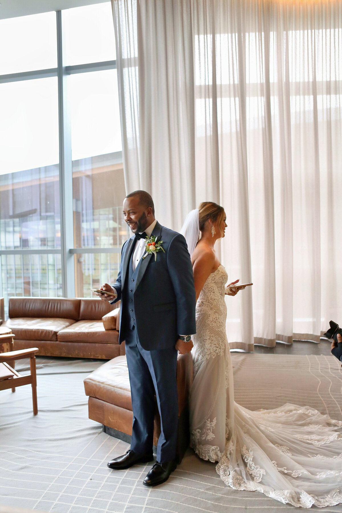 Bride and groom stand back to back and read vows to one another inside 1 Hotel Nashville