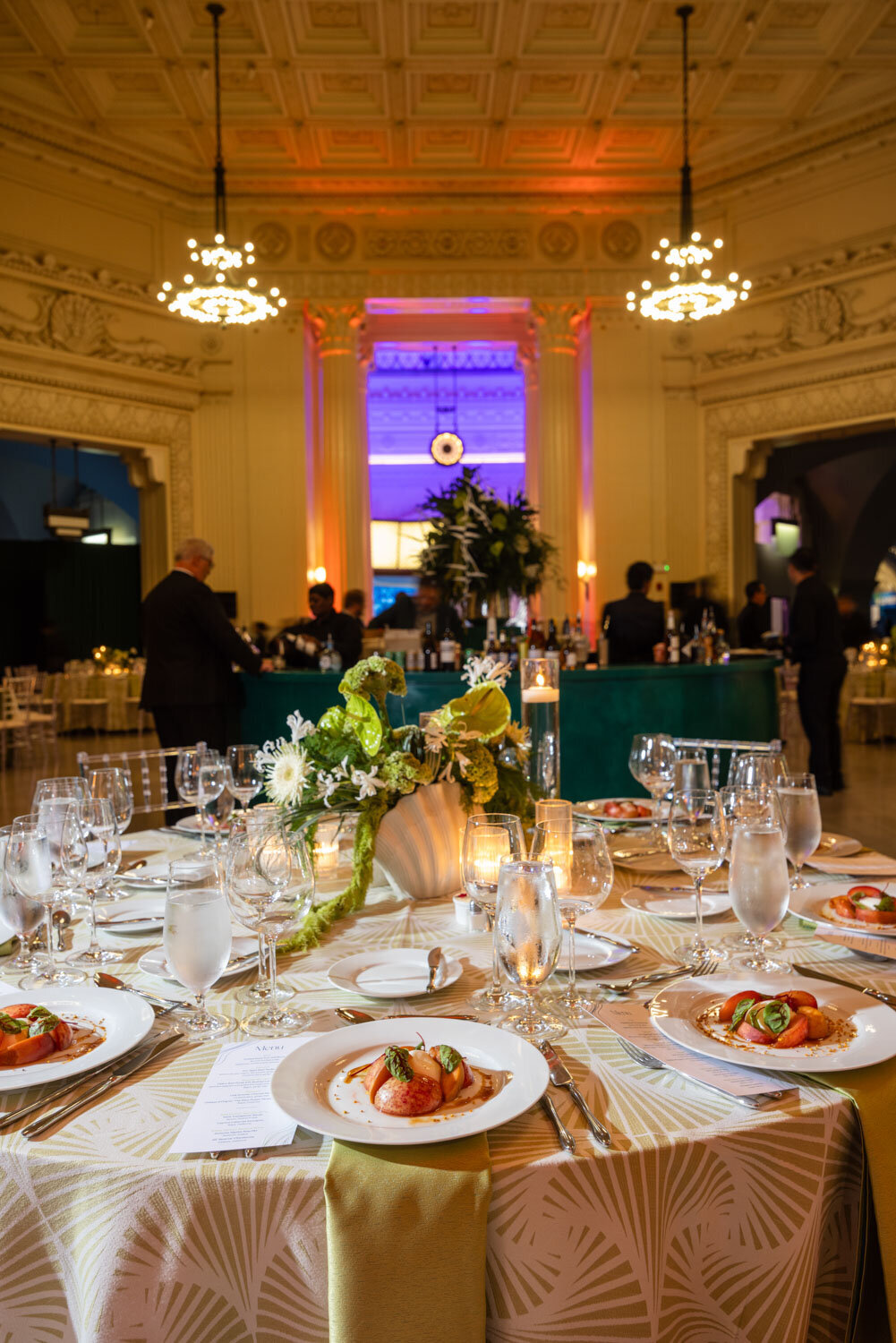 Elegant table setup with plated appetizers and candles in ballroom