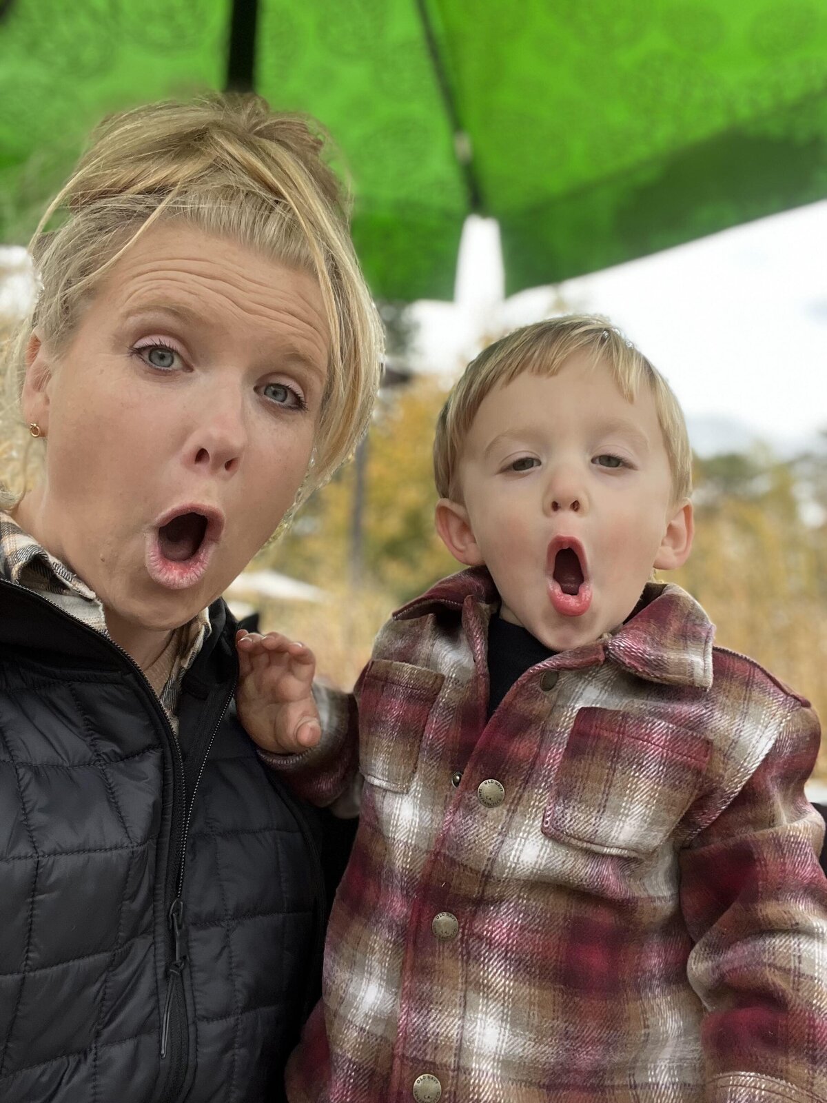 Toddler and mom make funny faces at the camera at playplace