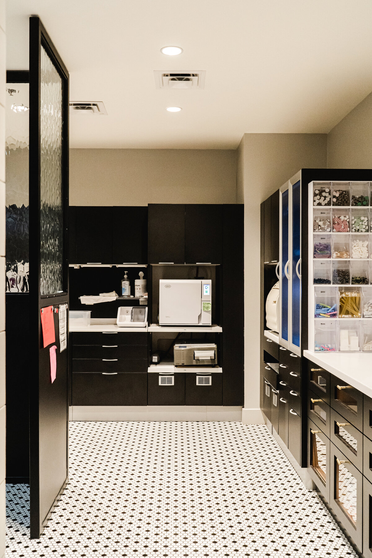 dentist and dental hygienist workroom with black cabinets and black and white tile flooring