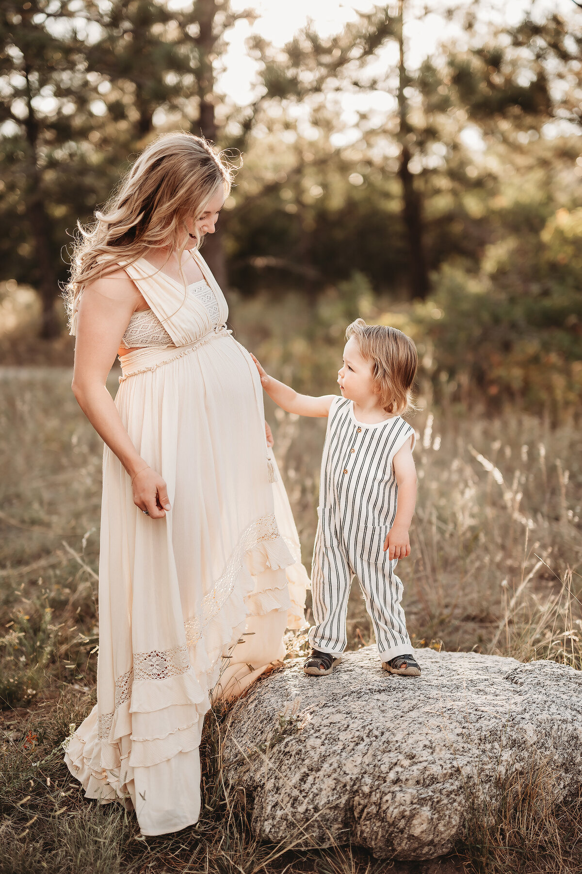 little boy pointing to mom's maternity belly