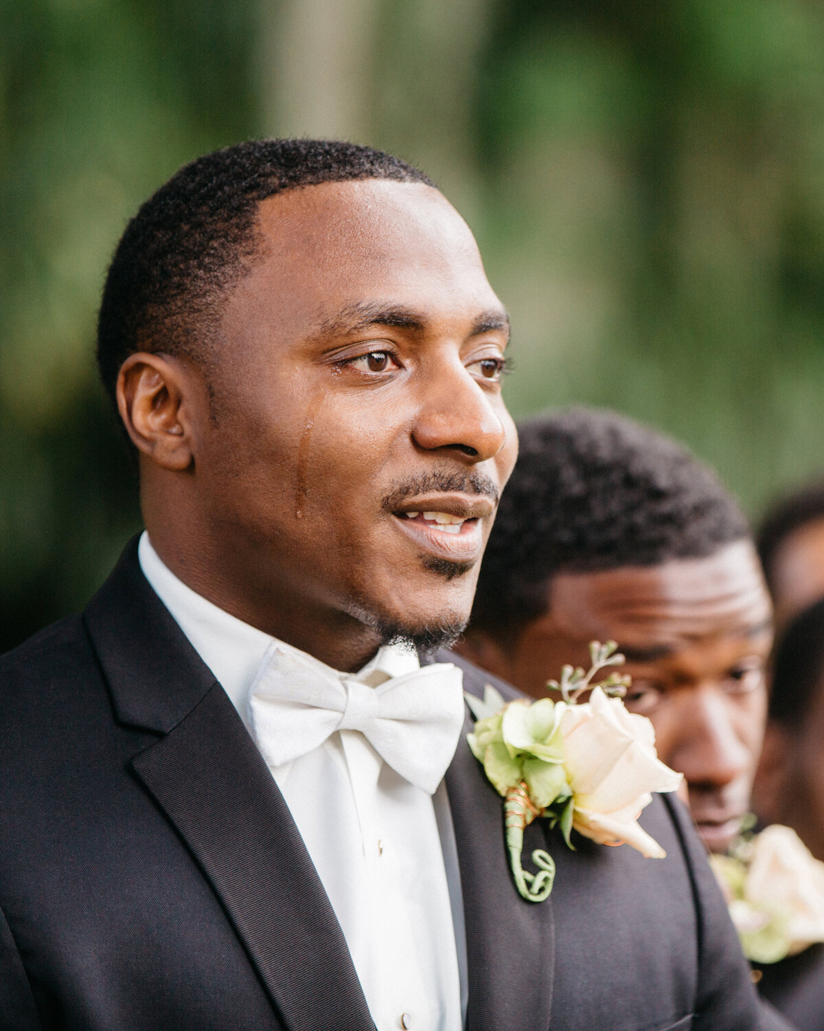 Groom crying as his bride walks down the aisle at their wedding.