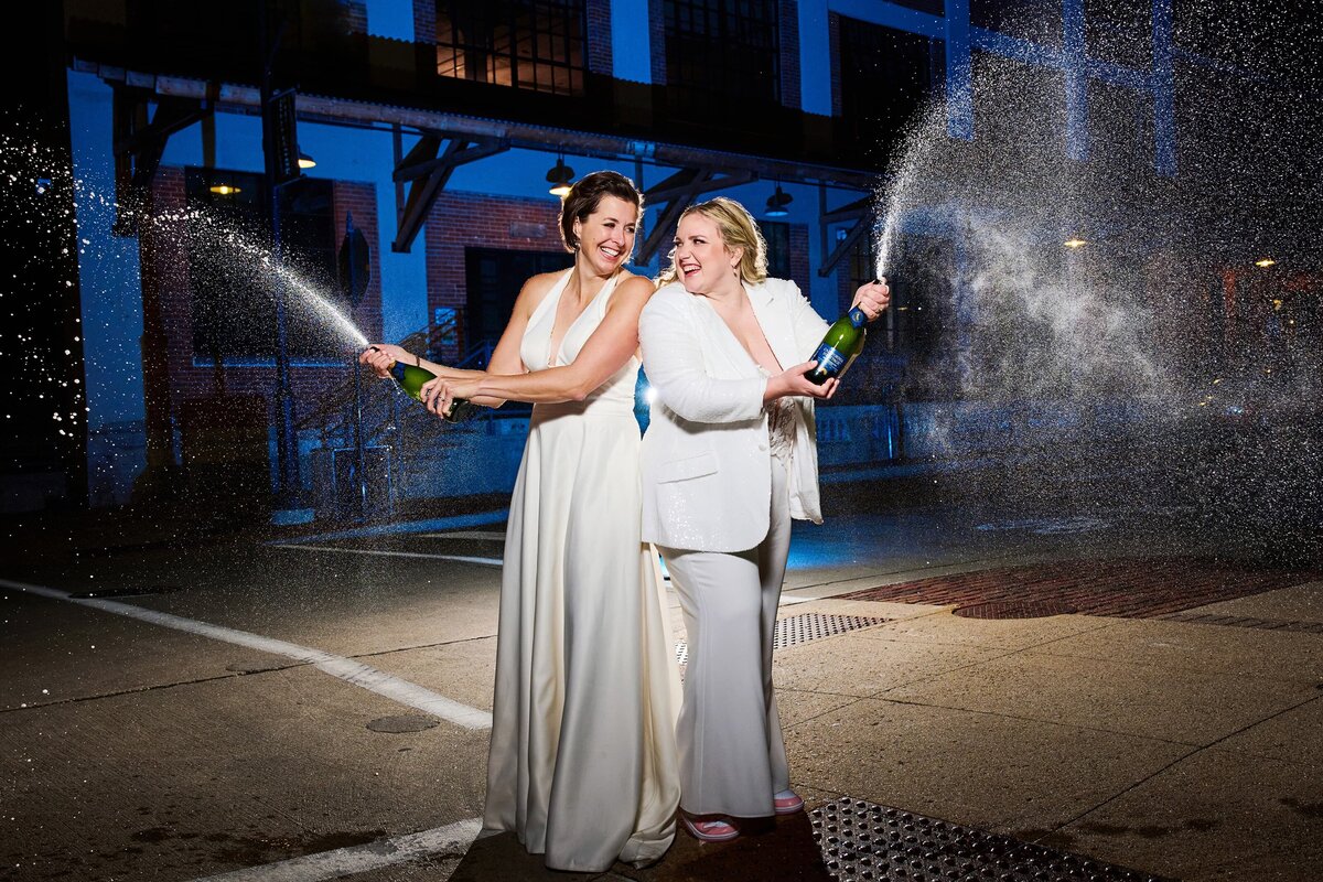 same sex couple spraying champaign
