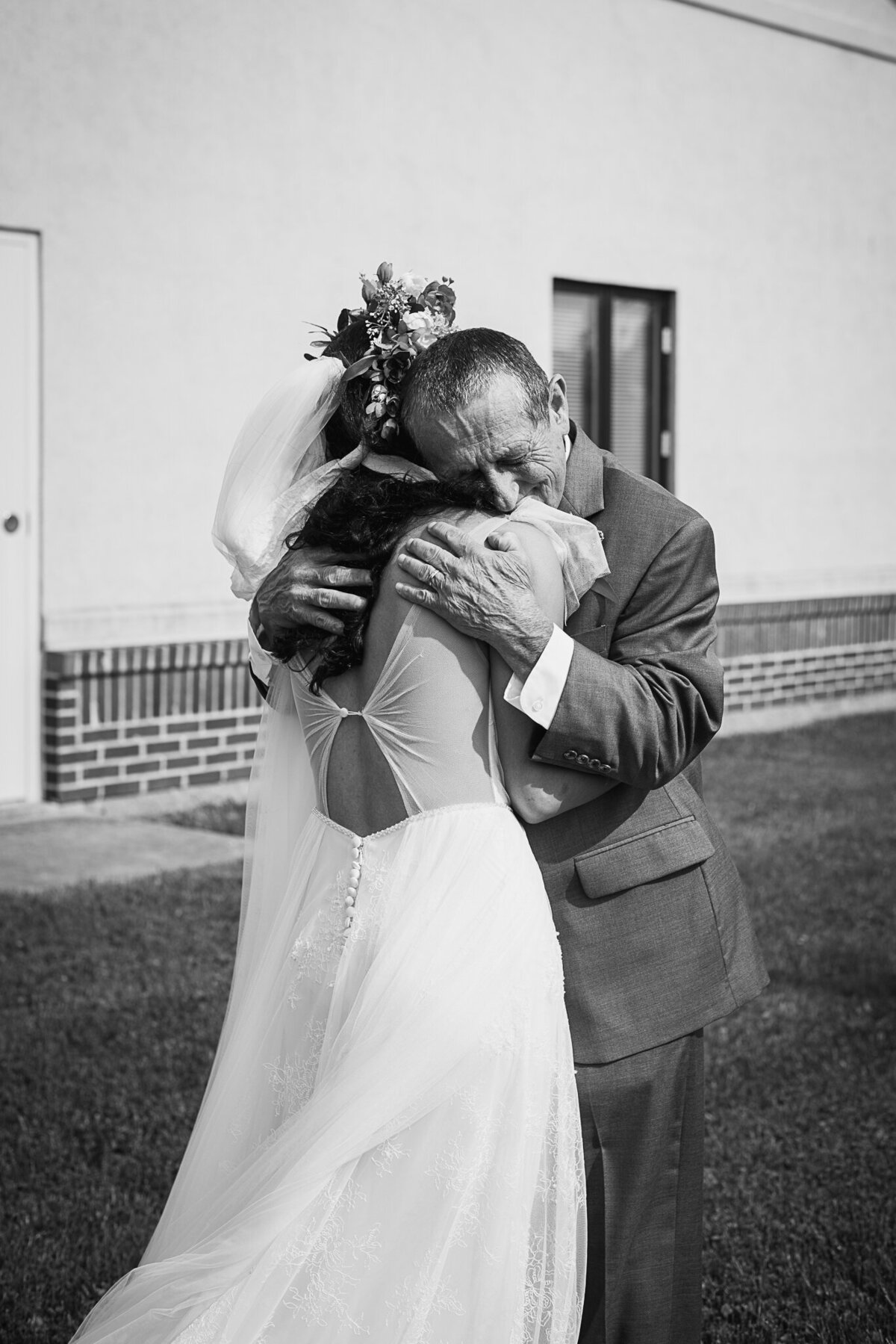 Bride, Ronicia Henderson, emotionally embraces her father during their first look on her wedding day in Xenia, Ohio.
