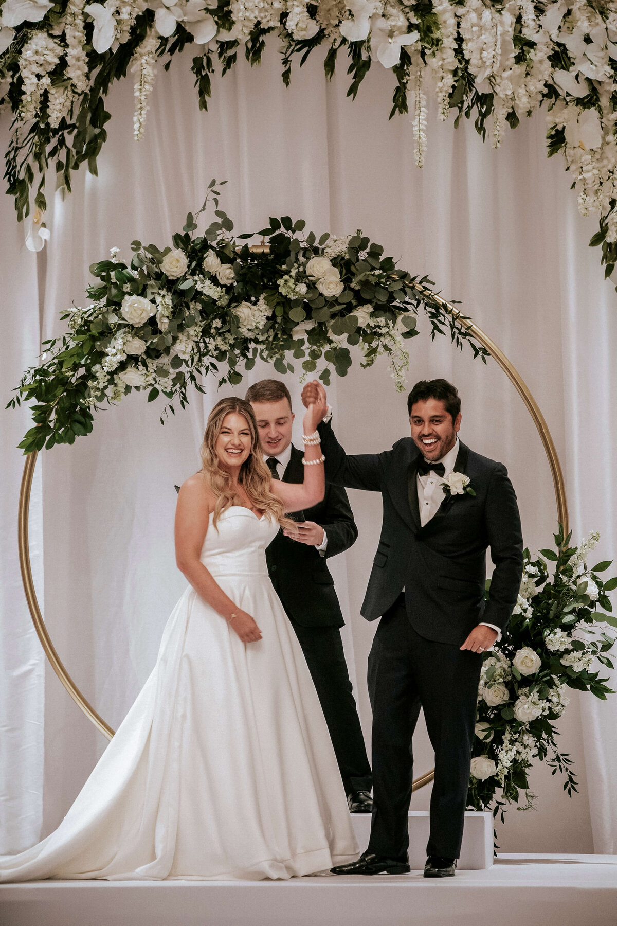 bride-and-groom-raising-hands-at-alter