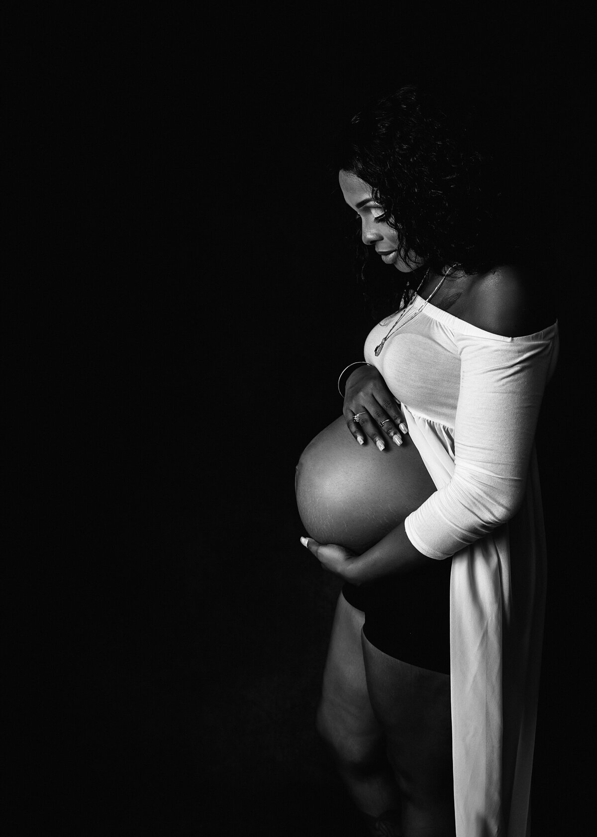 black and white portrait of mom admiring baby bump