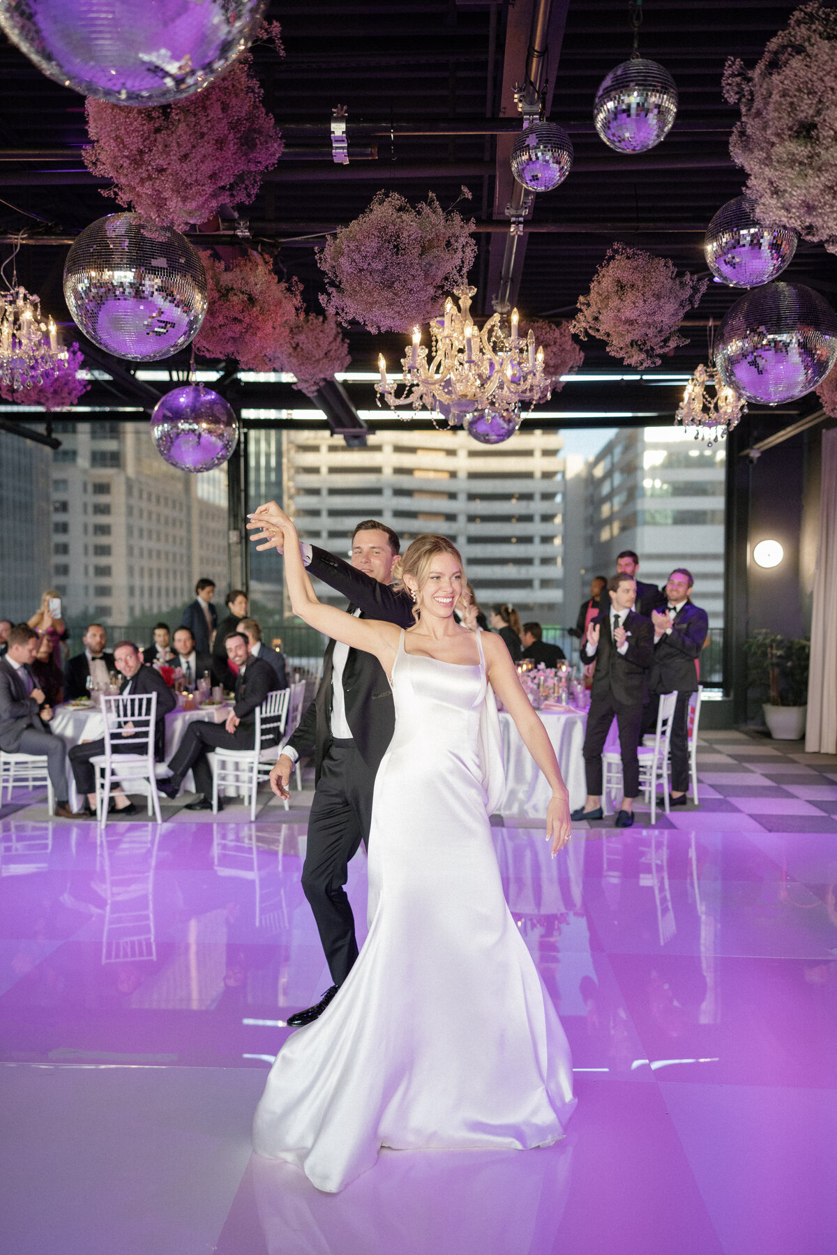 Groom spinning bride on dance floor at wedding