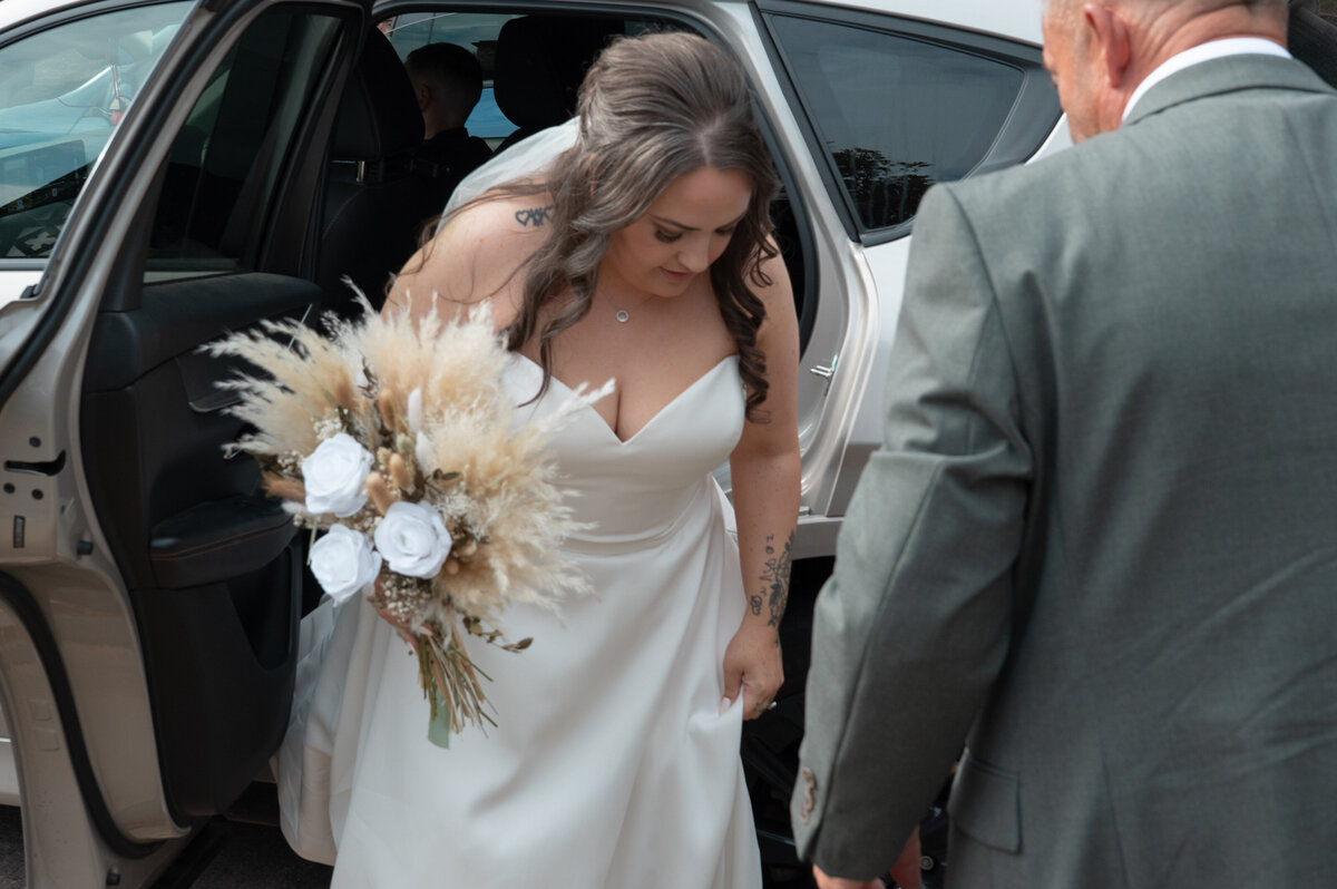 Bride exiting bridal car arrival at ceremony Worsley Court House 