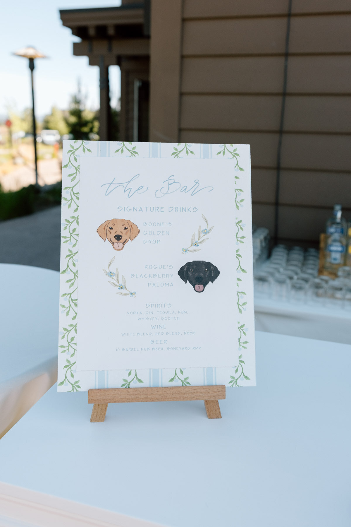 Wedding Bar menu sitting on a bar top with custom wallpaper and calligraphy details and puppy sketeches representing full service design and calligraphy by Life in Letters.