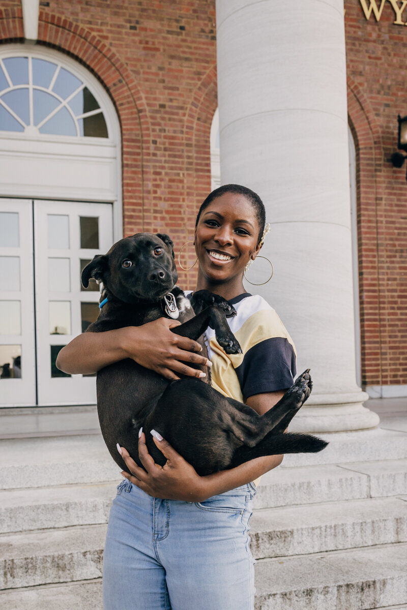 Vanderbilt University senior holding her black dog during graduation portrait session
