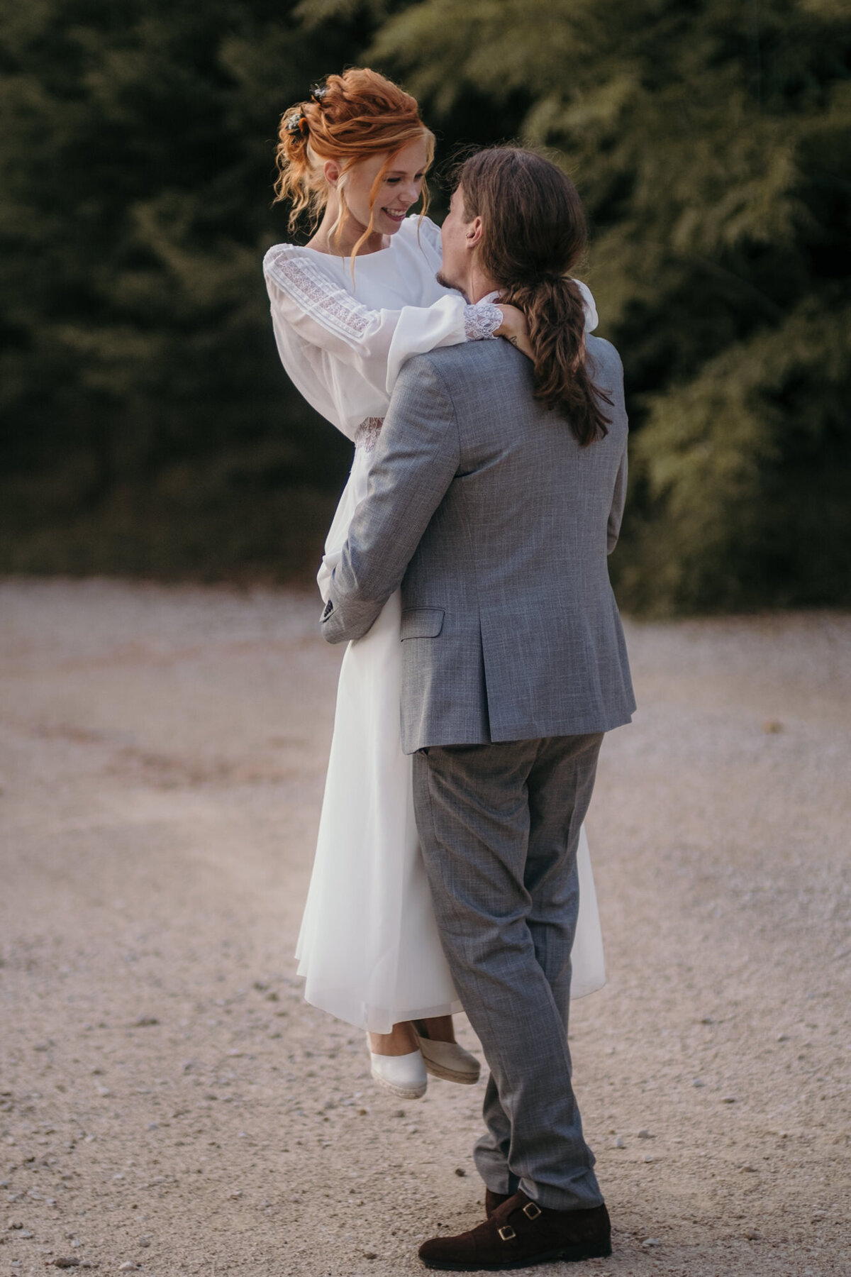 Wedding shooting at the beach with the groom holding up his bride.