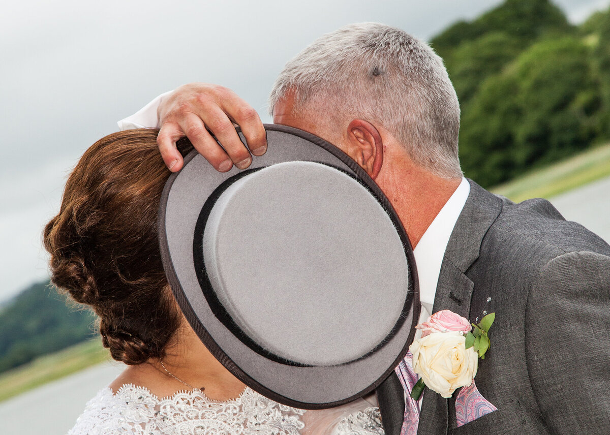 pro-story-photography_bride&groom-shy-kiss-top-hat_pentillie-castle_cornwall