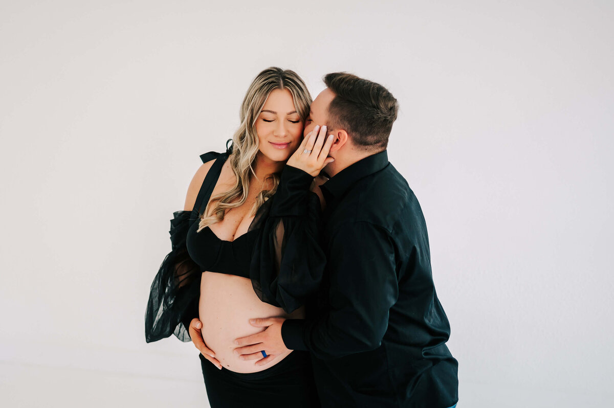 Springfield MO maternity photographer Jessica Kennedy of The XO Photography captures close up of husband kissing pregnant mom's cheek